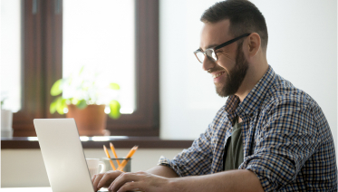 Man using laptop to rent a 1 yard dumpster online